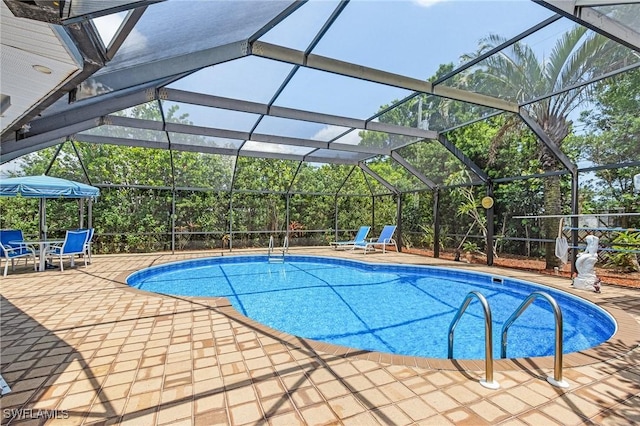 view of swimming pool with a patio and glass enclosure