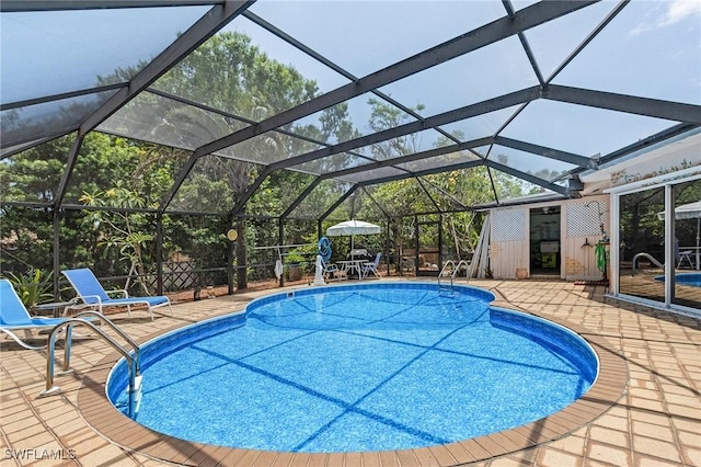 view of swimming pool featuring glass enclosure and a patio area