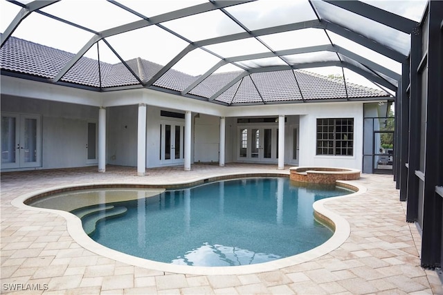 view of pool featuring glass enclosure, an in ground hot tub, french doors, and a patio