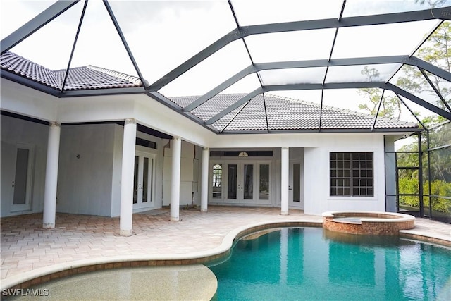 view of pool featuring glass enclosure, an in ground hot tub, french doors, and a patio