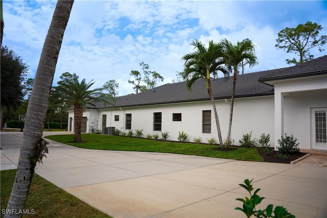 exterior space featuring a yard and central AC