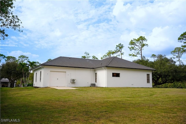 back of property featuring a yard and a garage