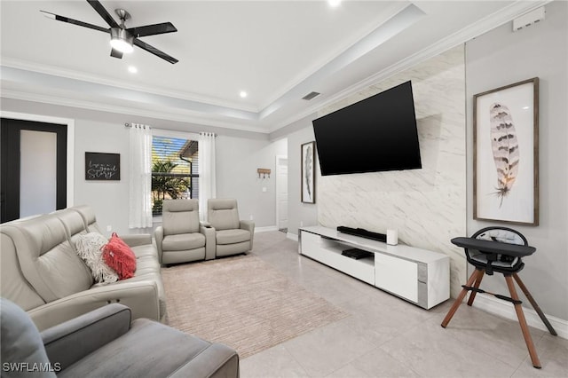 living room featuring a tray ceiling, ceiling fan, and ornamental molding