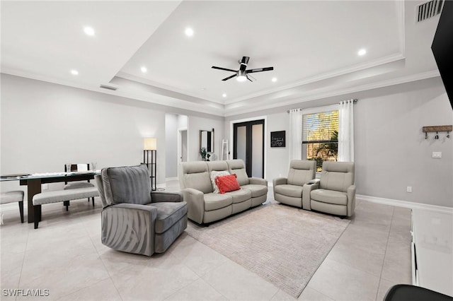 tiled living room featuring a raised ceiling, ceiling fan, and ornamental molding