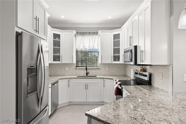 kitchen featuring white cabinets, stainless steel appliances, light stone countertops, and sink