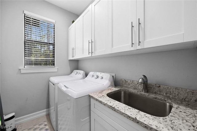 laundry room featuring washer and clothes dryer, cabinets, and sink