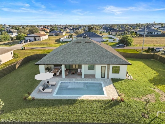 rear view of property with a lawn, a patio, an outdoor hangout area, and a fenced in pool