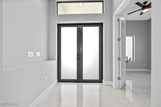 foyer featuring plenty of natural light, ceiling fan, and french doors