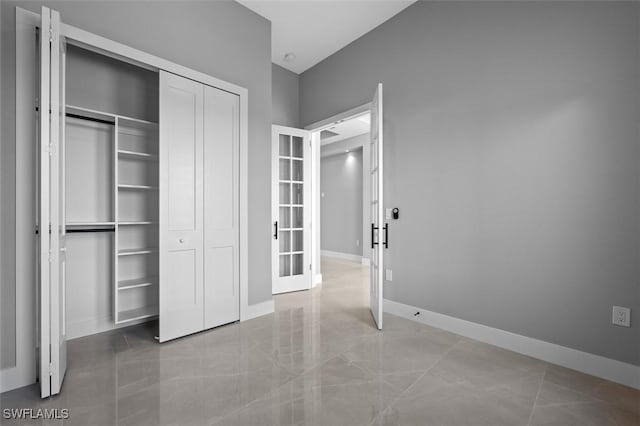 unfurnished bedroom with a closet and french doors