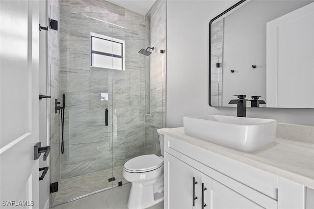 bathroom featuring vanity, an enclosed shower, and toilet