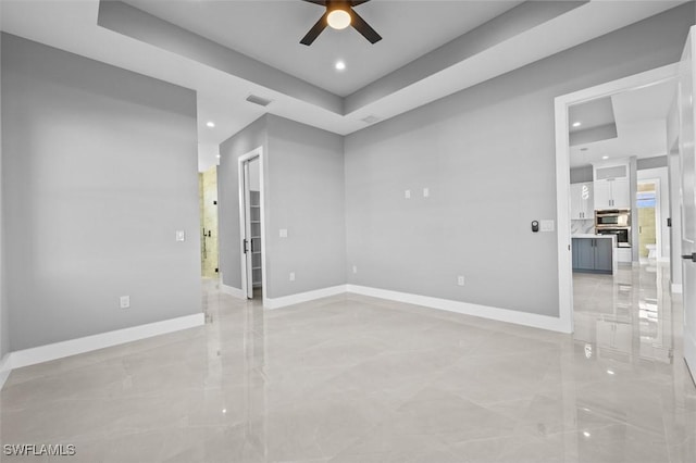 unfurnished room with a tray ceiling and ceiling fan