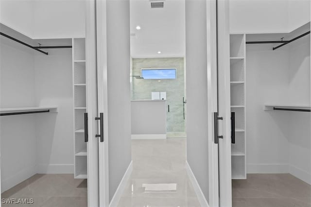 spacious closet with light tile patterned floors