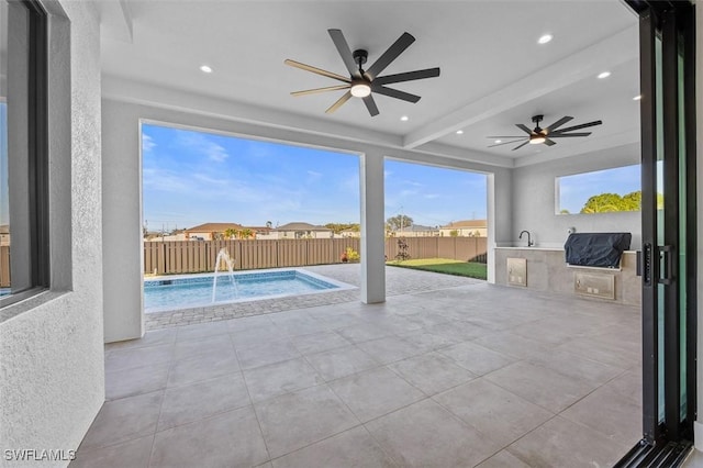 view of patio / terrace featuring a fenced in pool, pool water feature, ceiling fan, and exterior kitchen