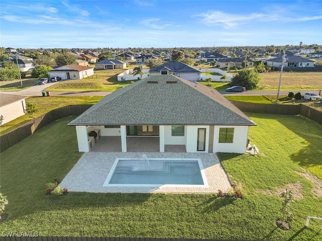 back of house featuring a lawn, a fenced in pool, and a patio