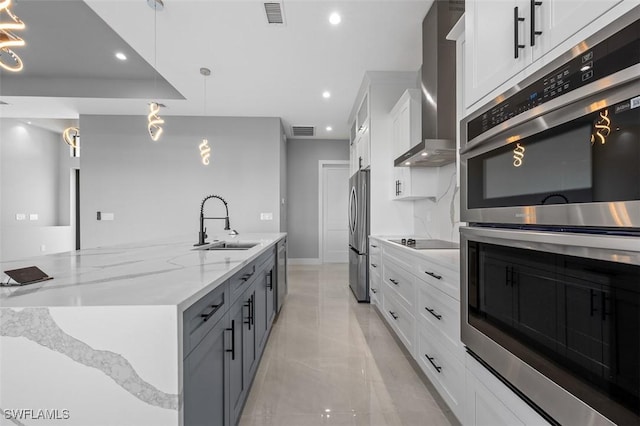 kitchen with pendant lighting, white cabinets, sink, and appliances with stainless steel finishes