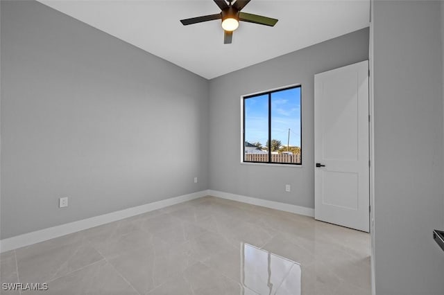 tiled spare room featuring ceiling fan