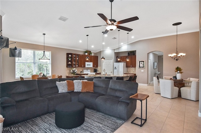 living room featuring ceiling fan with notable chandelier, lofted ceiling, sink, ornamental molding, and light tile patterned flooring