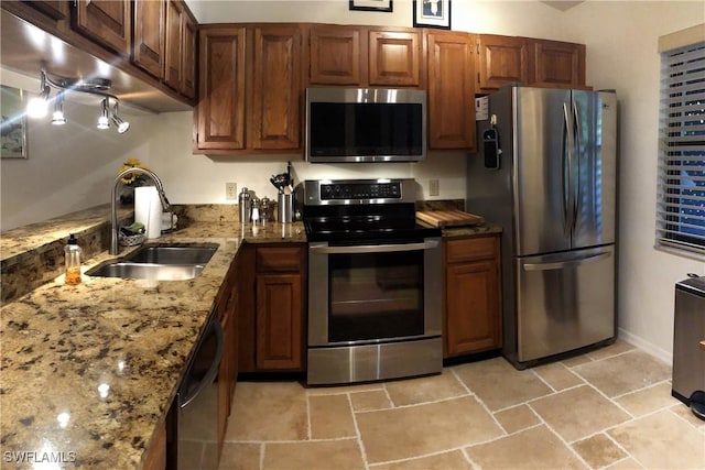 kitchen featuring light stone countertops, appliances with stainless steel finishes, and sink