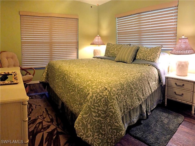 bedroom with dark hardwood / wood-style flooring