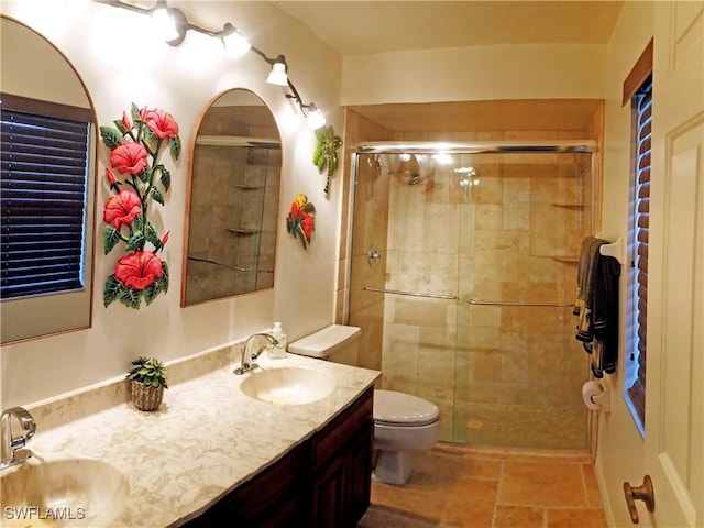 bathroom with vanity, a shower with shower door, and toilet