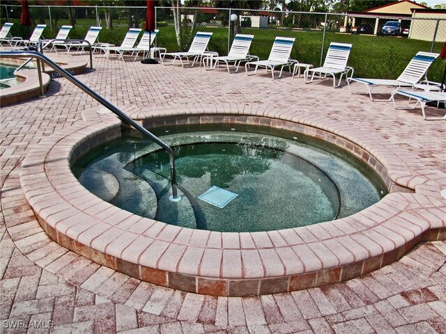 view of swimming pool with a patio and a hot tub