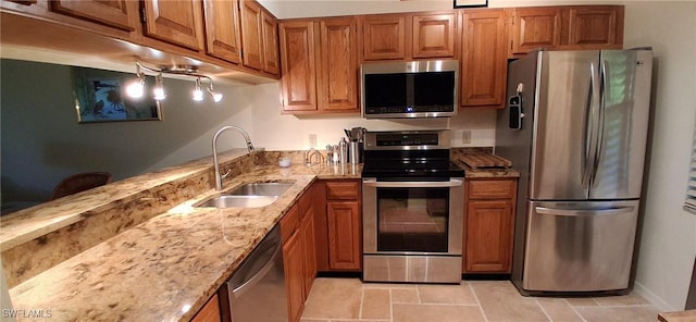 2056 Pine Isle Ln Unit 2056, Naples, FL 34112 - kitchen with stainless steel appliances, a sink, brown cabinetry, and light stone counters