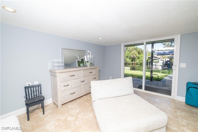 living area with a wall of windows and light tile patterned flooring