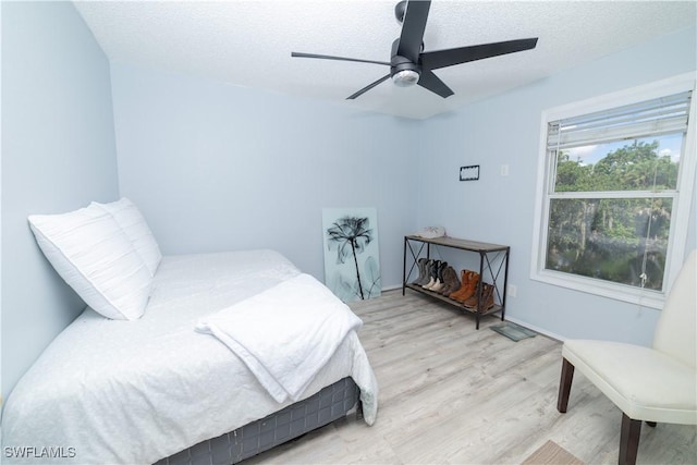 bedroom featuring ceiling fan, a textured ceiling, and light hardwood / wood-style flooring