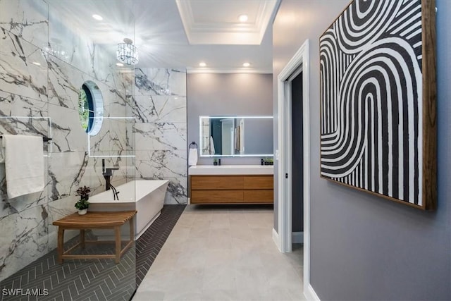 bathroom featuring vanity, tile walls, a bath, a tray ceiling, and crown molding