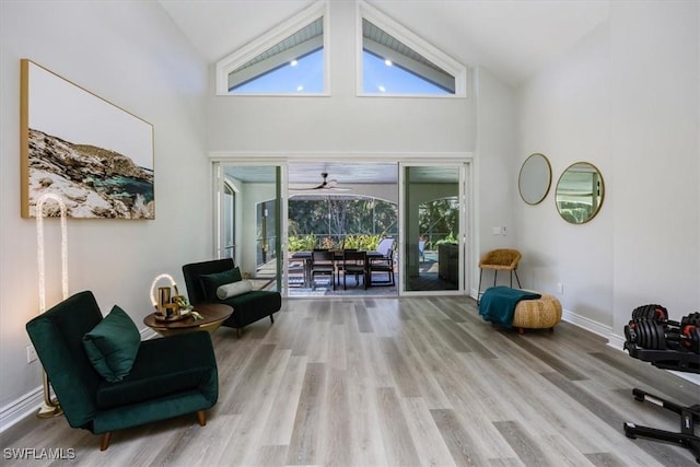 sitting room with light hardwood / wood-style flooring and high vaulted ceiling