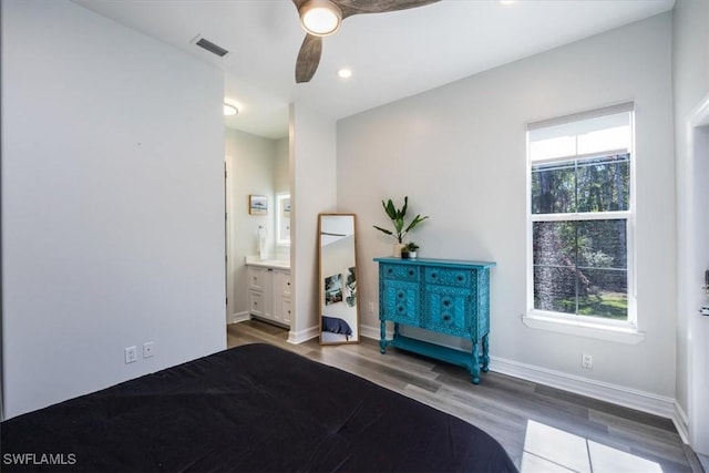 unfurnished bedroom with ceiling fan, connected bathroom, and hardwood / wood-style floors