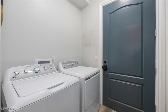 laundry room with hardwood / wood-style floors and separate washer and dryer