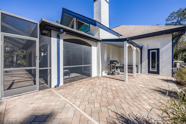 rear view of property with a lanai and a patio area