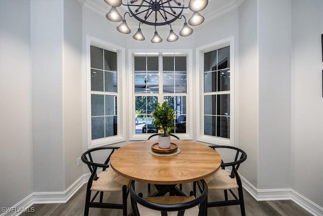 dining space featuring a chandelier, ornamental molding, and dark hardwood / wood-style flooring