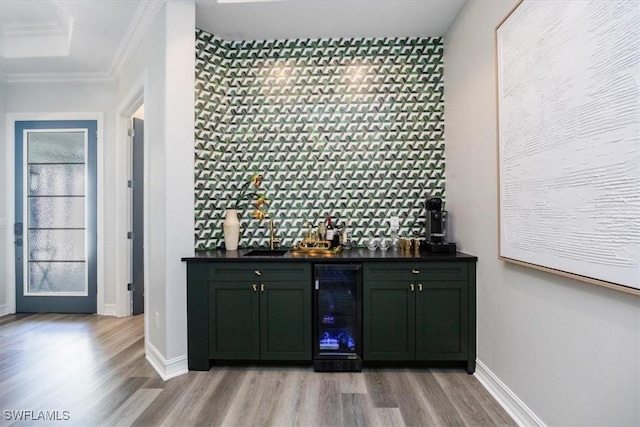 bar featuring crown molding, light hardwood / wood-style floors, wine cooler, and a tray ceiling