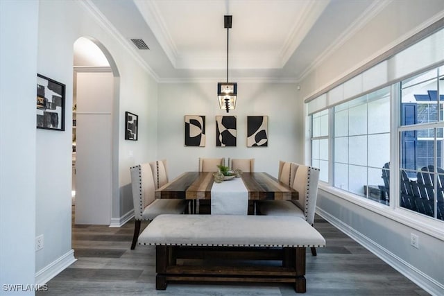 dining room with crown molding, dark hardwood / wood-style flooring, and a tray ceiling