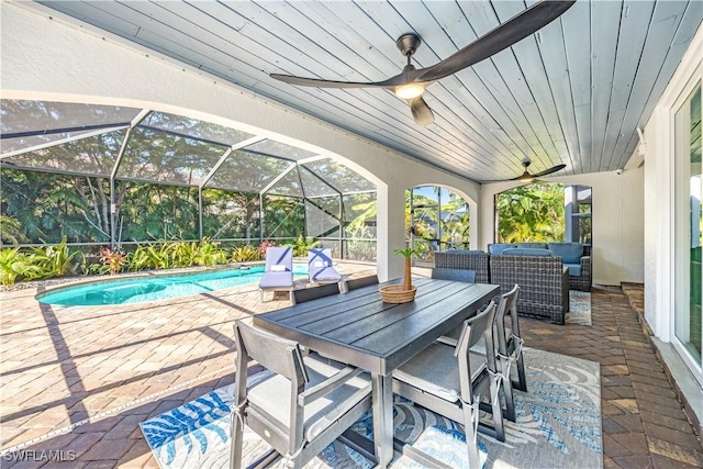 view of patio featuring ceiling fan and glass enclosure