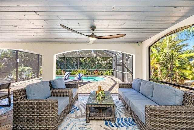 sunroom with ceiling fan, a wealth of natural light, and wood ceiling