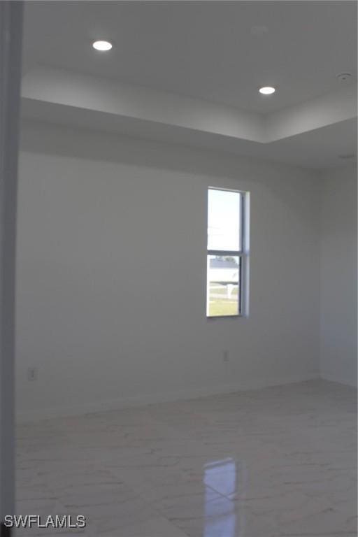 unfurnished room featuring a tray ceiling