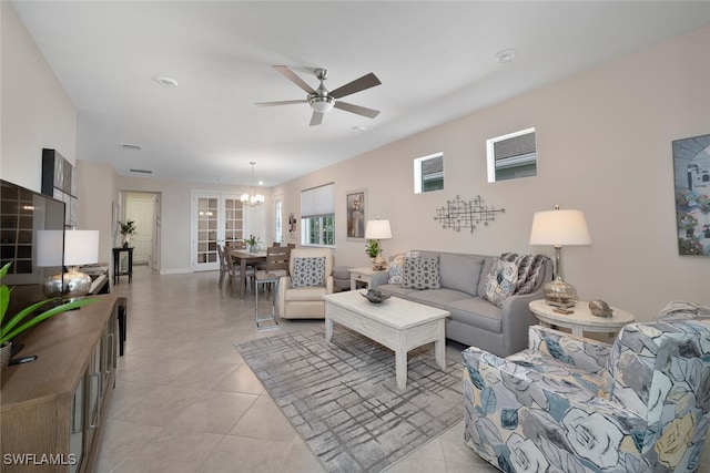 living room featuring ceiling fan with notable chandelier and light tile patterned flooring