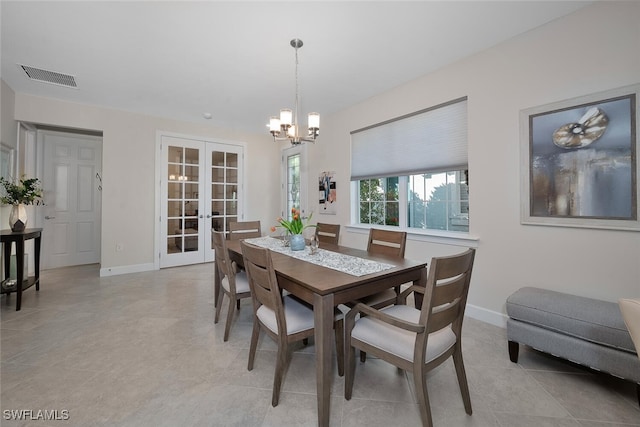 dining space with french doors, light tile patterned flooring, and a chandelier