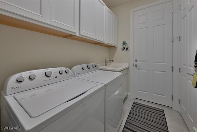 laundry area with separate washer and dryer, sink, light tile patterned flooring, and cabinets