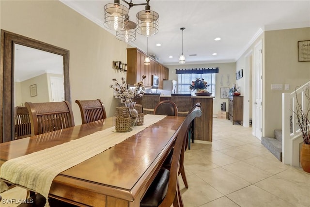 dining space with light tile patterned floors, an inviting chandelier, and crown molding