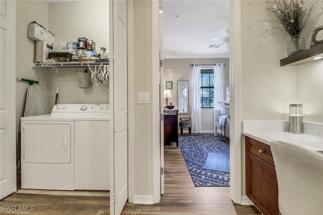 clothes washing area featuring crown molding, hardwood / wood-style floors, and washer and dryer