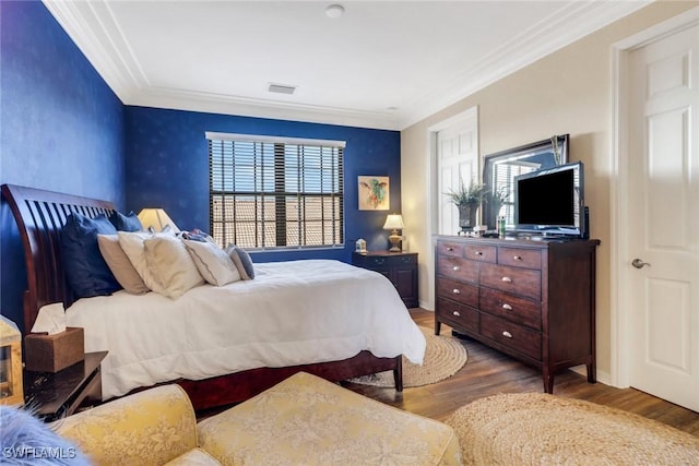 bedroom featuring wood-type flooring and ornamental molding