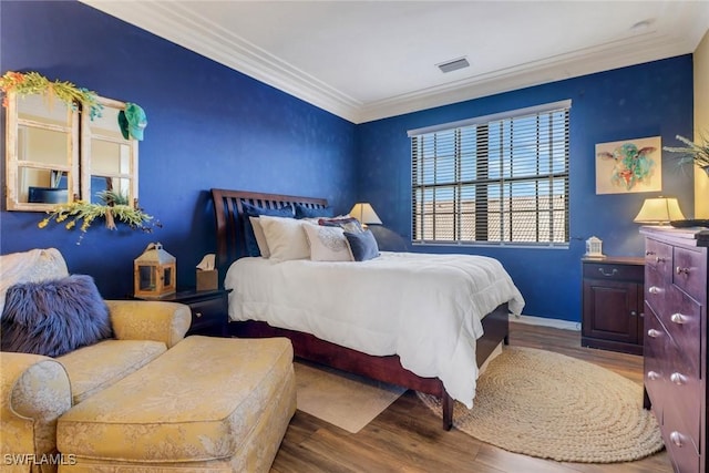 bedroom with wood-type flooring and crown molding