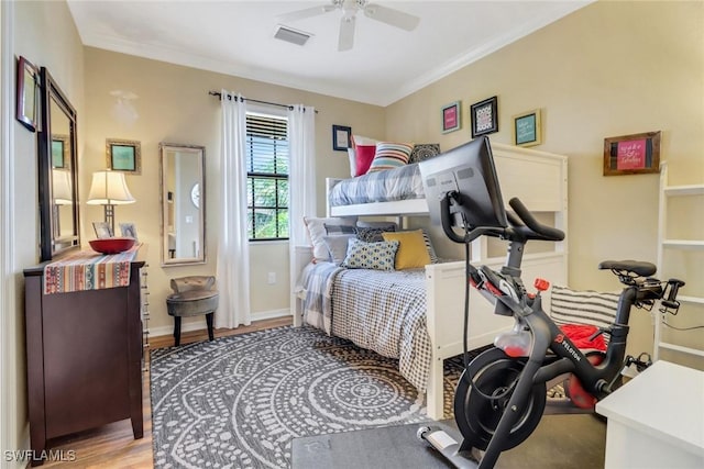 bedroom with ceiling fan, ornamental molding, and light hardwood / wood-style flooring