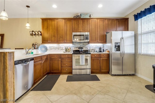 kitchen featuring sink, hanging light fixtures, ornamental molding, appliances with stainless steel finishes, and tasteful backsplash