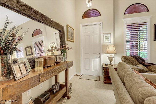 foyer entrance with light tile patterned flooring and a high ceiling