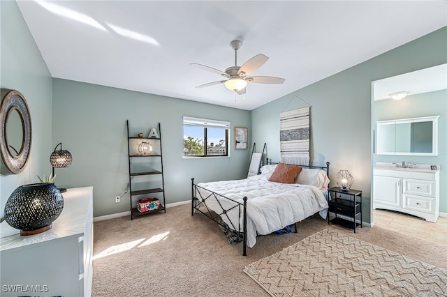 carpeted bedroom featuring ceiling fan, vaulted ceiling, sink, and ensuite bath